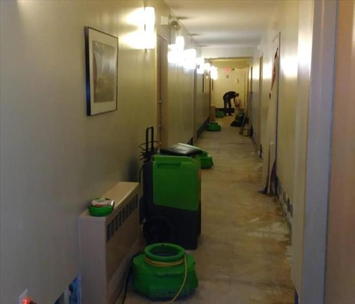 Commercial hallway with flood cuts and green equipment.